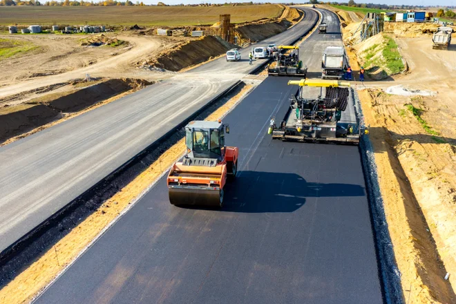 Straßenbauarbeiten mit Asphaltiermaschine und Baupersonal – symbolisch für die digitale Baustellenabwicklung mit Pro-Bau/S® AddOne im Straßenbau.